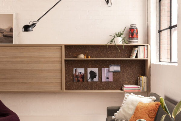 Custom shelving, timber flooring, and joinerty against painted brick walls in the Milanote Melbourne office fitout, adding texture, display space and character to the open workspace.
