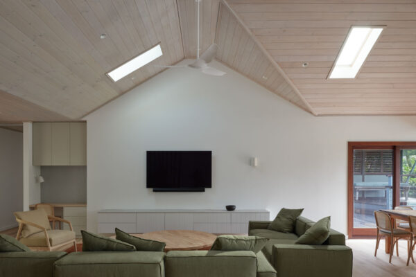 Living area in the MacGregor renovation in Suffolk Park, featuring vaulted timber-lined ceilings, built-in joinery and a relaxed open-plan coastal interior.
