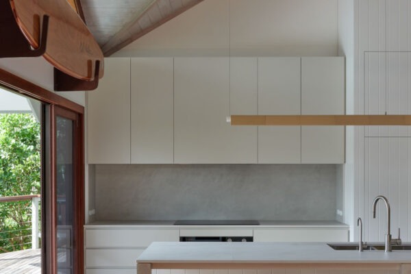 MacGregor renovation in Suffolk Park, featuring a vaulted timber-lined ceiling, white joinery, island bench and warm coastal finishes.