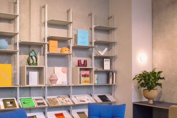 Lounge and reading nook in the Fliteboard Office Fitout in Byron Bay, featuring polished concrete floors, display shelving, and soft furnishings.