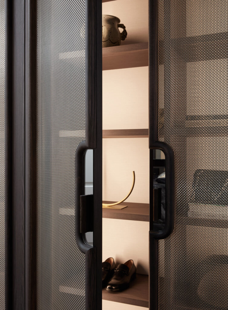 Dark timber joinery with mesh cabinet doors in the Buley project in Hawthorn East, Melbourne, showcasing refined storage detailing and a luxurious interior finish.